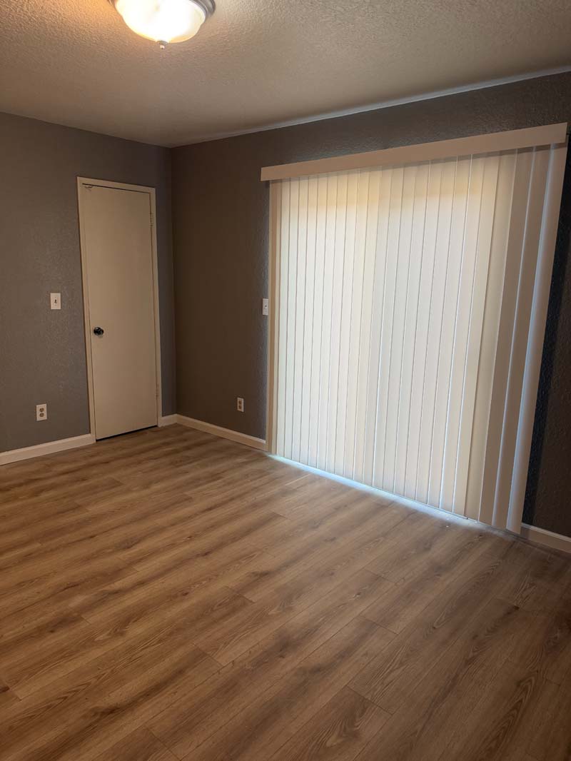 Living area with sliding glass door and wood-look flooring at 674 Gannet Ct